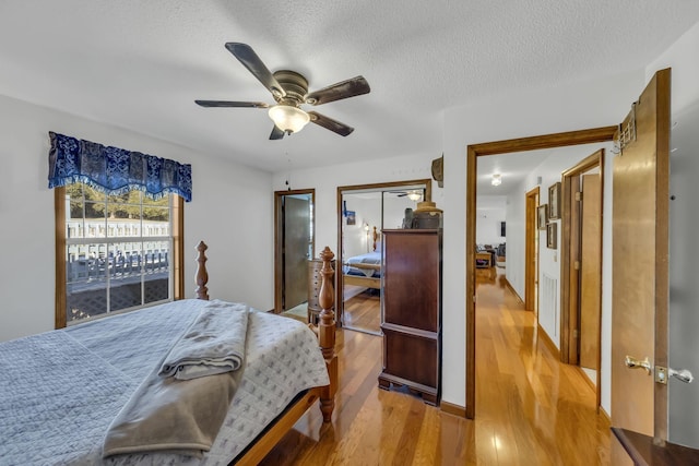 bedroom featuring ceiling fan, a textured ceiling, and light wood-type flooring