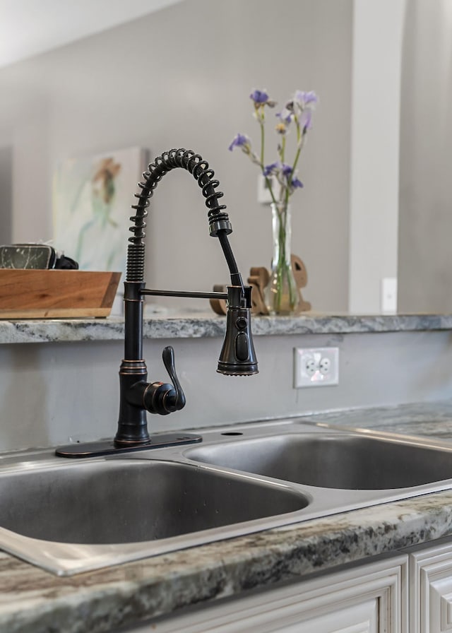 room details featuring white cabinets and sink