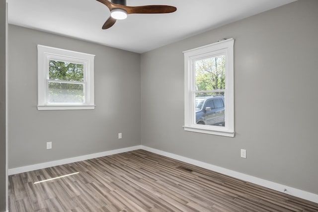 empty room with ceiling fan and light hardwood / wood-style flooring