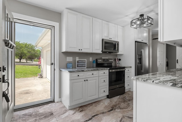 kitchen featuring appliances with stainless steel finishes, white cabinets, and light stone countertops