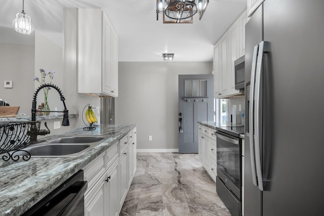 kitchen featuring appliances with stainless steel finishes, white cabinetry, light stone counters, and sink