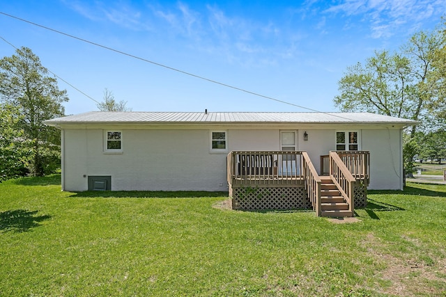 back of property featuring a lawn and a wooden deck