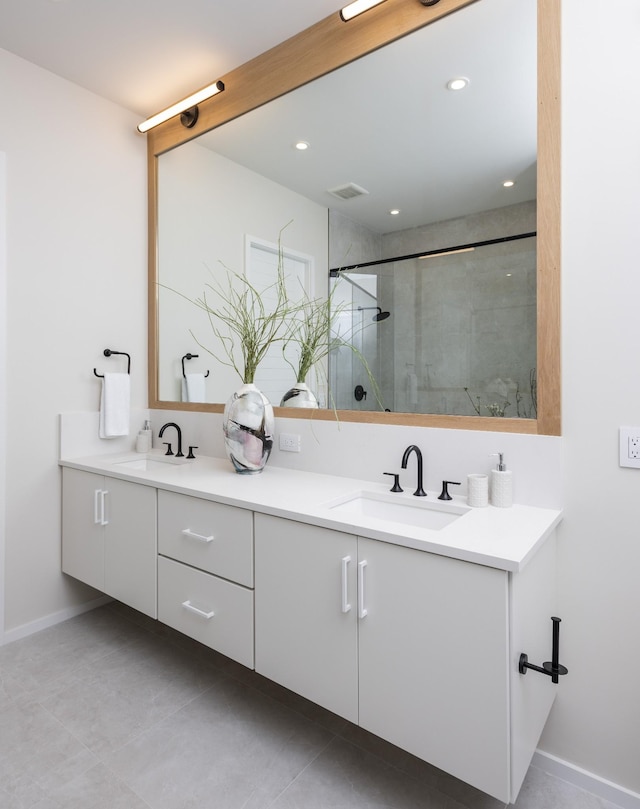 bathroom featuring tile patterned flooring, a shower with door, and vanity