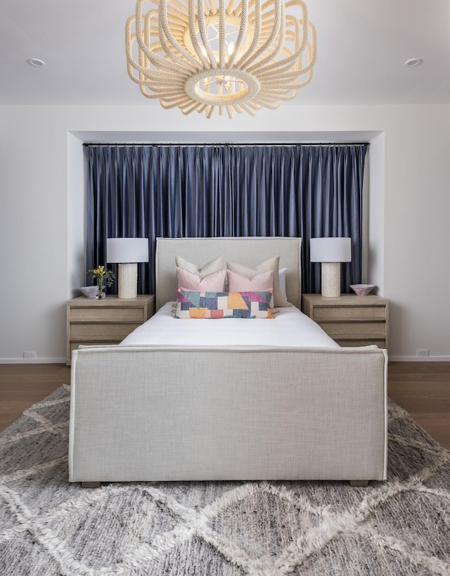 bedroom with hardwood / wood-style floors and a notable chandelier