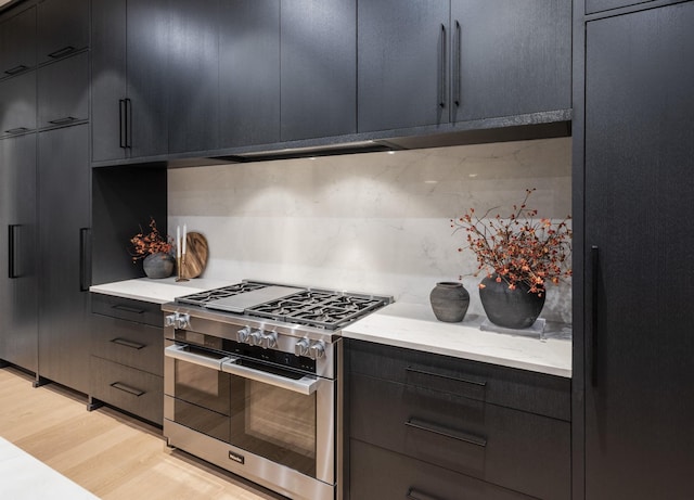 kitchen featuring double oven range, refrigerator, light hardwood / wood-style flooring, and tasteful backsplash