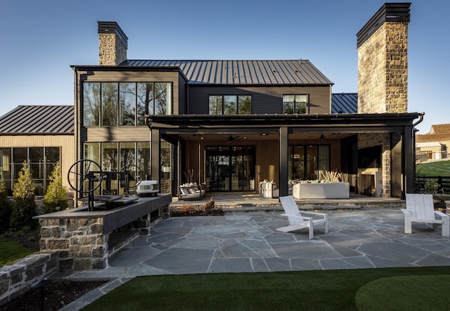 rear view of property with ceiling fan and a patio