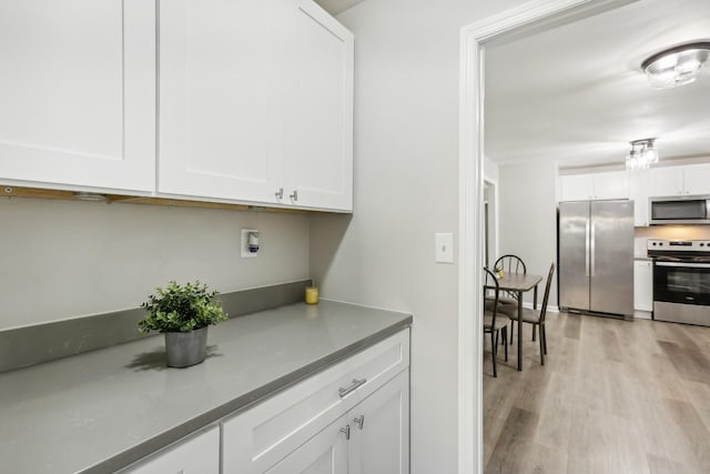 kitchen featuring light hardwood / wood-style floors, white cabinetry, and stainless steel appliances