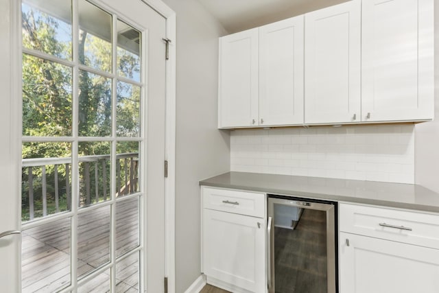 kitchen featuring white cabinets, backsplash, beverage cooler, and a wealth of natural light