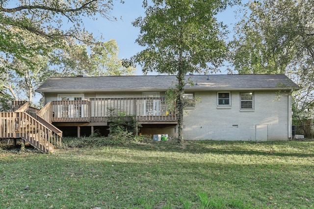 rear view of house featuring a wooden deck and a lawn