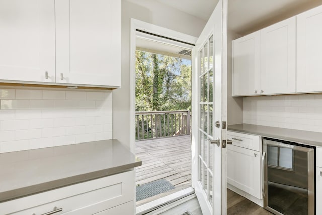 kitchen featuring wine cooler and white cabinets