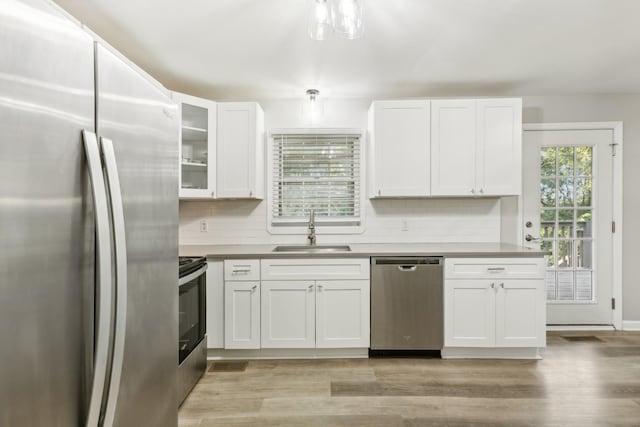 kitchen featuring stainless steel appliances, white cabinetry, and sink