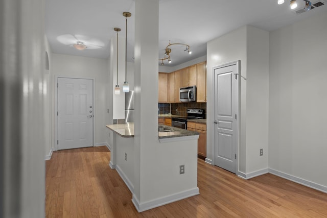 kitchen featuring appliances with stainless steel finishes, decorative backsplash, light brown cabinets, hanging light fixtures, and light hardwood / wood-style flooring