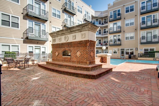 view of swimming pool featuring a patio and exterior fireplace