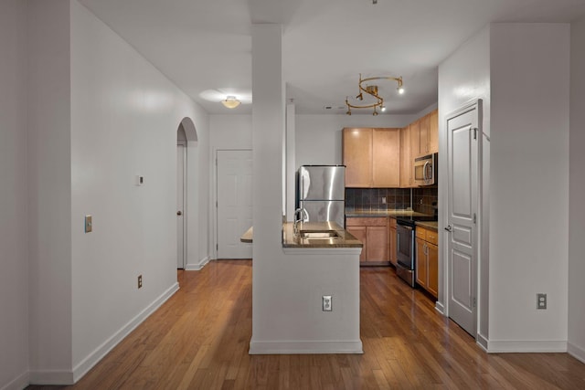 kitchen with backsplash, sink, light brown cabinets, and stainless steel appliances