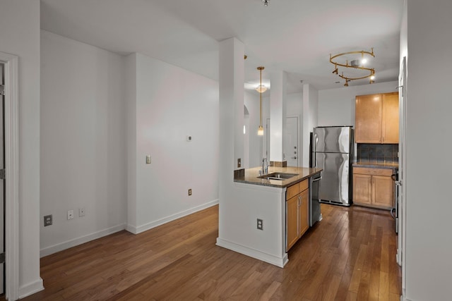 kitchen with dark wood-type flooring, light brown cabinets, stainless steel appliances, decorative backsplash, and sink