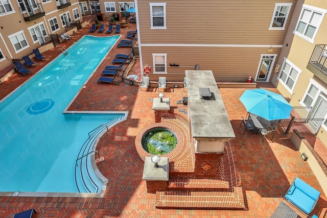 view of swimming pool featuring a community hot tub and a patio