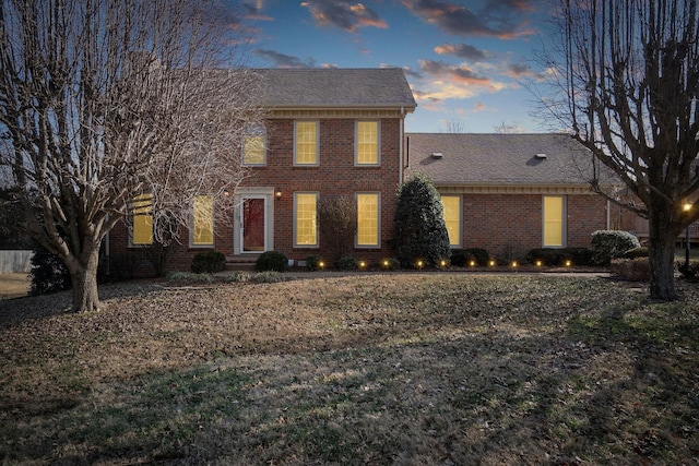 colonial-style house featuring a yard