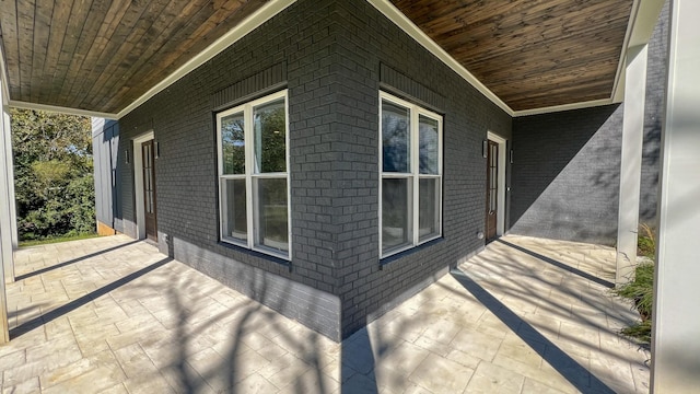 view of side of home with a porch and brick siding