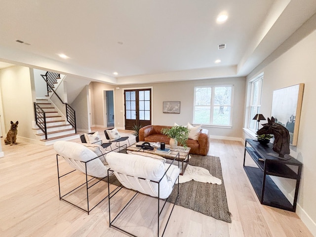 living room featuring light wood finished floors, recessed lighting, visible vents, baseboards, and stairs