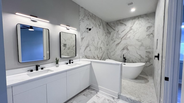 full bathroom with a freestanding tub, a sink, visible vents, marble finish floor, and double vanity