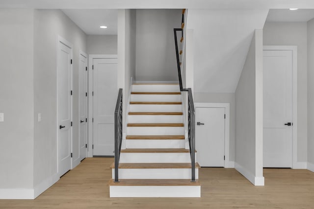 stairway with wood finished floors and baseboards