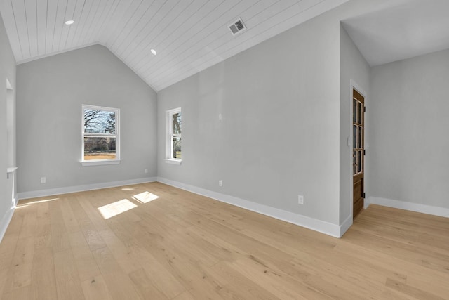 spare room with lofted ceiling, visible vents, light wood-style flooring, and baseboards