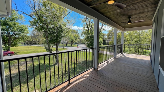 wooden deck with a ceiling fan and a lawn