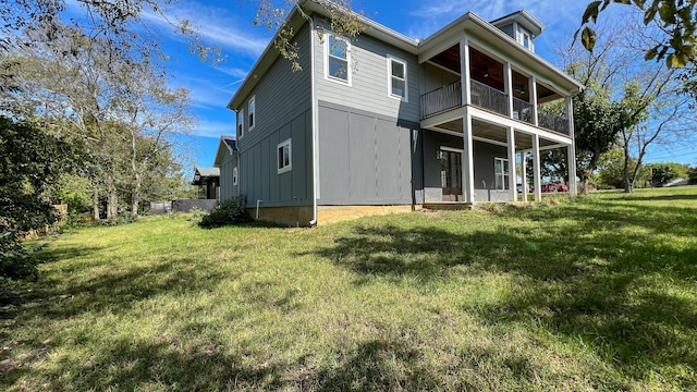 rear view of property featuring a yard and a balcony