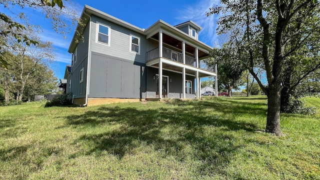 back of house featuring a balcony and a lawn