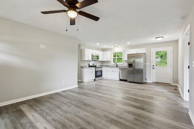 kitchen with plenty of natural light, ceiling fan, appliances with stainless steel finishes, and white cabinets