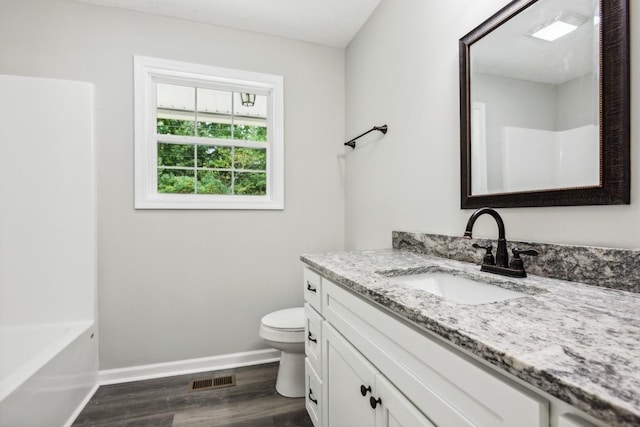 bathroom with toilet, hardwood / wood-style floors, and vanity