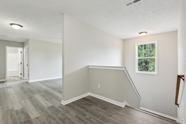 interior space with a textured ceiling and dark wood-type flooring