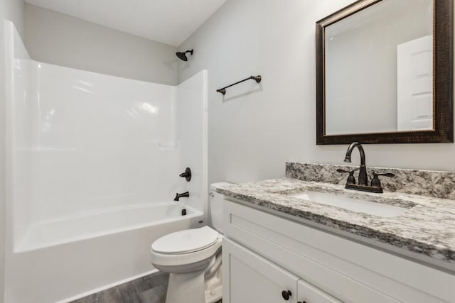 full bathroom with toilet,  shower combination, wood-type flooring, and vanity