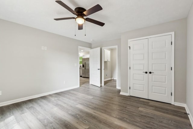 unfurnished bedroom featuring ceiling fan, dark hardwood / wood-style flooring, stainless steel fridge with ice dispenser, and a closet