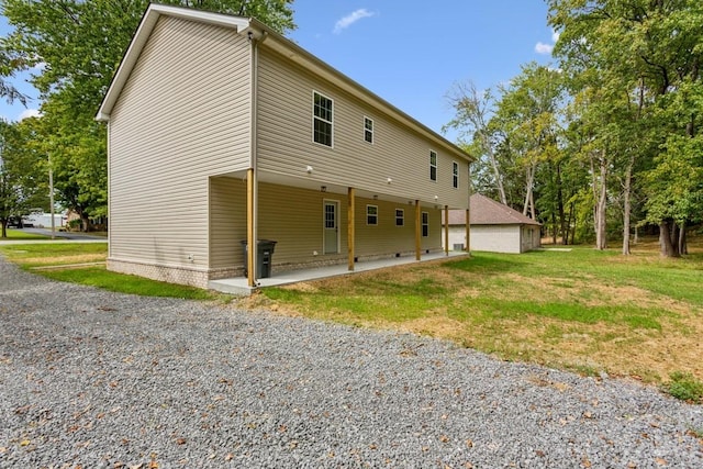 back of property with a patio area and a lawn