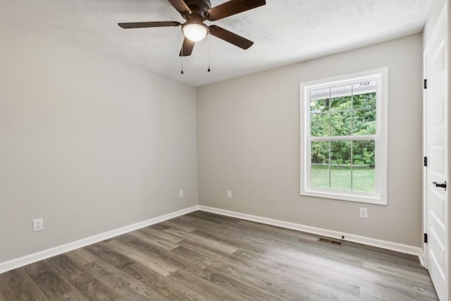 empty room with ceiling fan and dark hardwood / wood-style floors