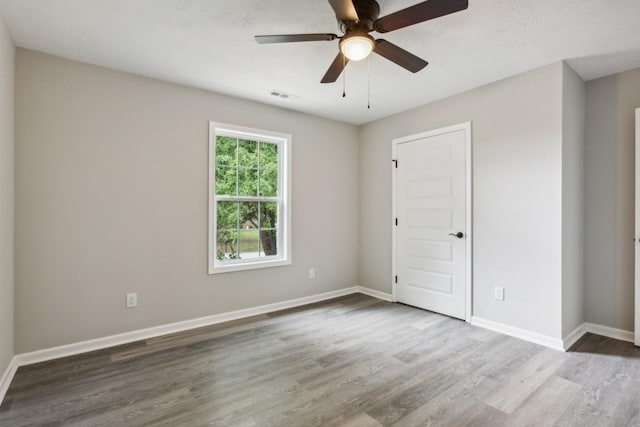 unfurnished room with ceiling fan and hardwood / wood-style flooring