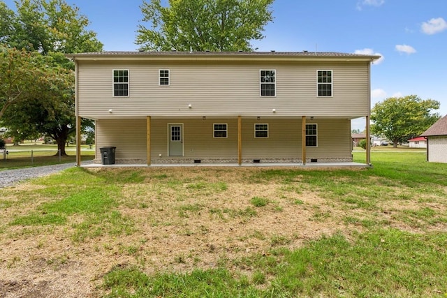 rear view of house featuring a lawn