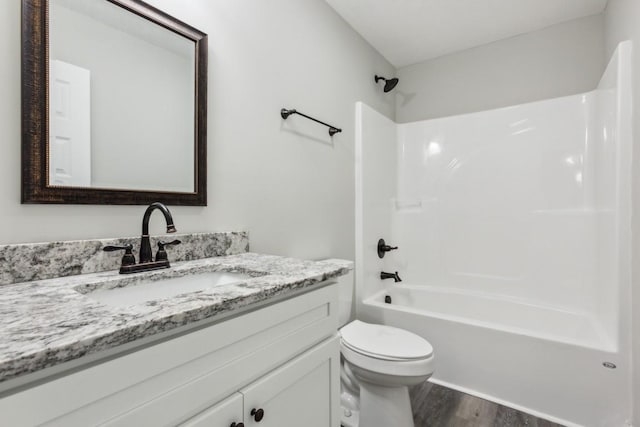 full bathroom featuring toilet, wood-type flooring, vanity, and bathtub / shower combination