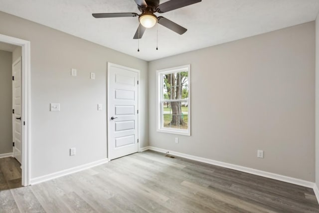 empty room with ceiling fan and wood-type flooring