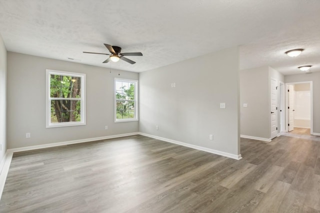 unfurnished room with a textured ceiling, ceiling fan, and hardwood / wood-style flooring