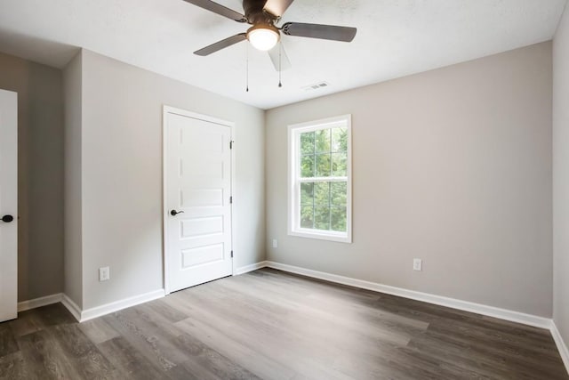 empty room featuring ceiling fan and dark hardwood / wood-style floors