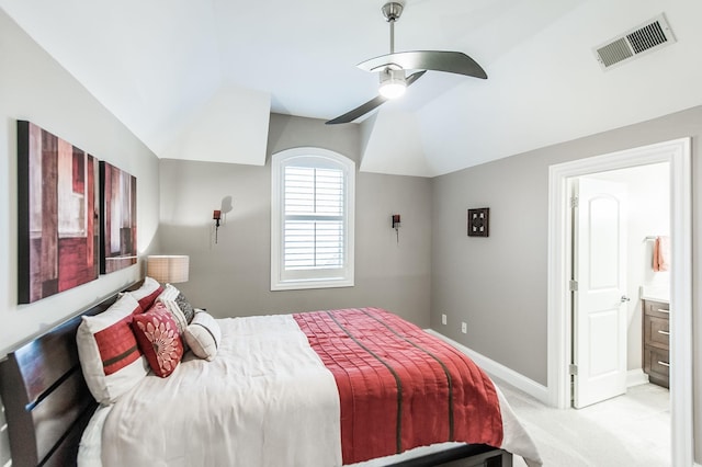 carpeted bedroom with ensuite bathroom, lofted ceiling, and ceiling fan