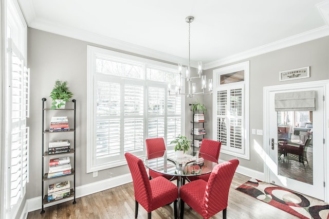 dining space featuring hardwood / wood-style flooring, ornamental molding, and an inviting chandelier