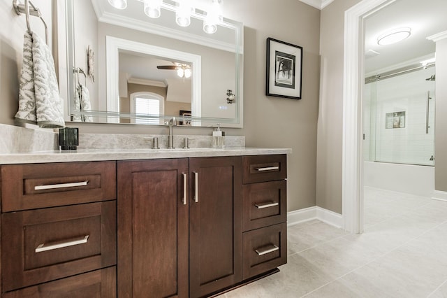 bathroom with tile patterned floors, combined bath / shower with glass door, ornamental molding, vanity, and ceiling fan