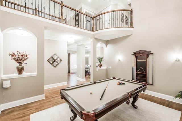 recreation room featuring hardwood / wood-style floors, a towering ceiling, and billiards