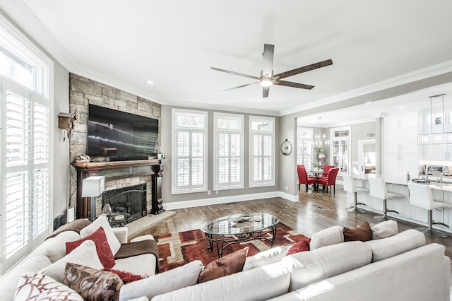 living room with ornamental molding, a stone fireplace, ceiling fan, and light hardwood / wood-style floors