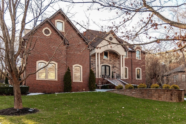 tudor-style house featuring a front yard