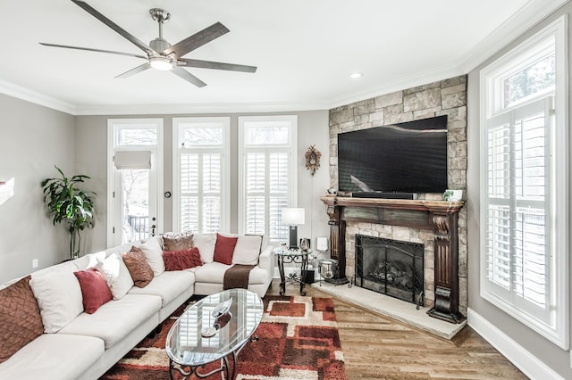 living room with hardwood / wood-style floors, crown molding, a fireplace, and a healthy amount of sunlight