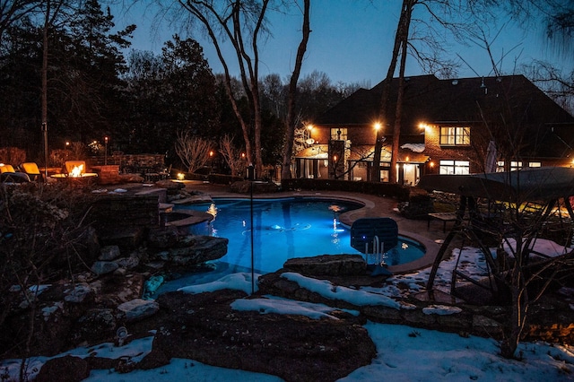 snow covered pool featuring a fire pit